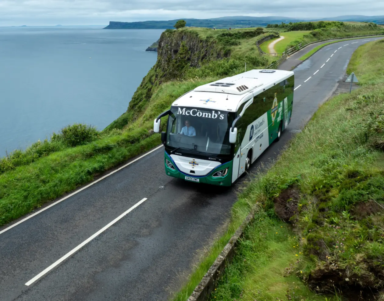 Coach driving through the hills by the sea